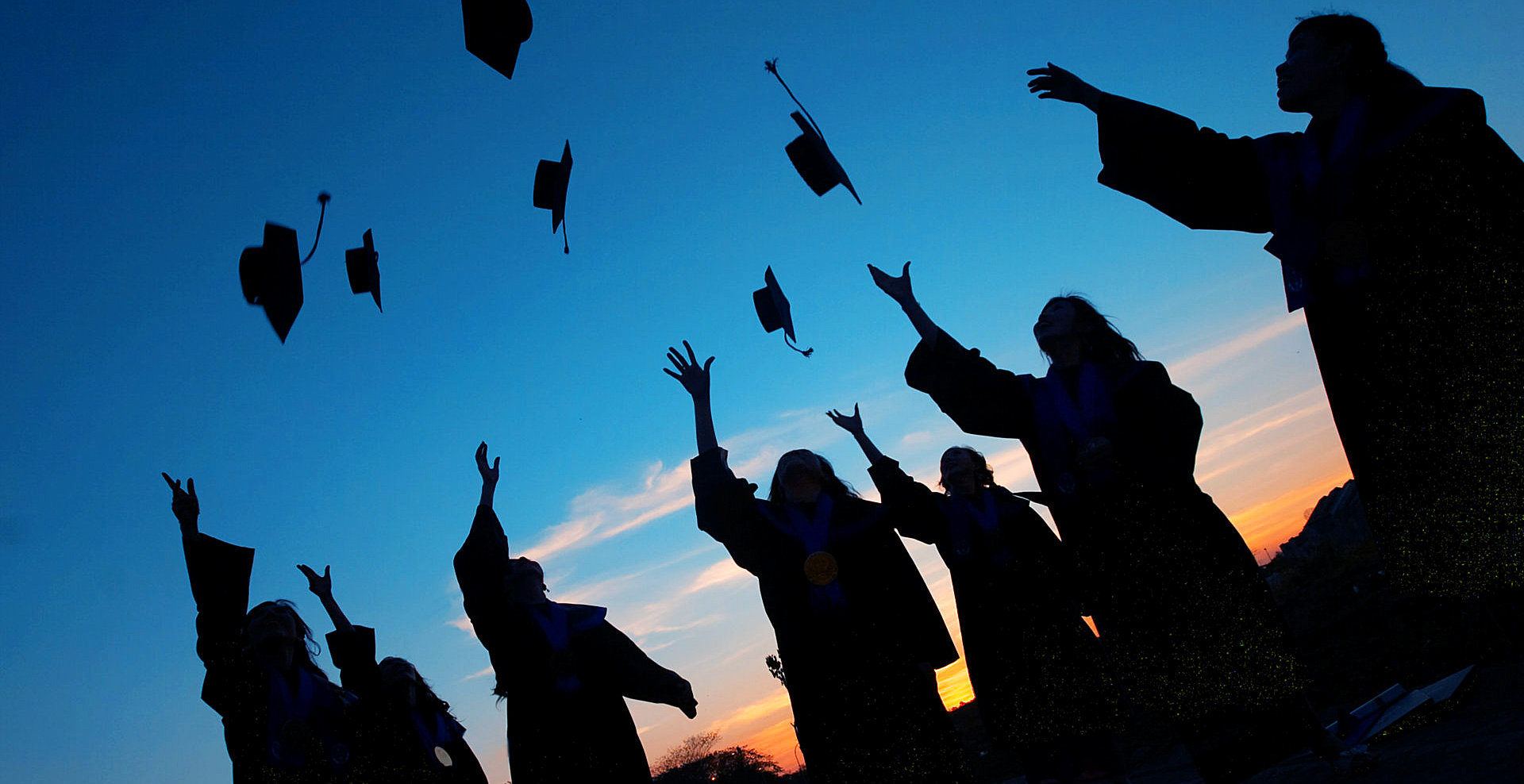 group of graduates throwing their graduation cup