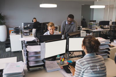 business colleagues working on computers at desk in office