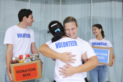 Happy volunteer group with food donation boxes